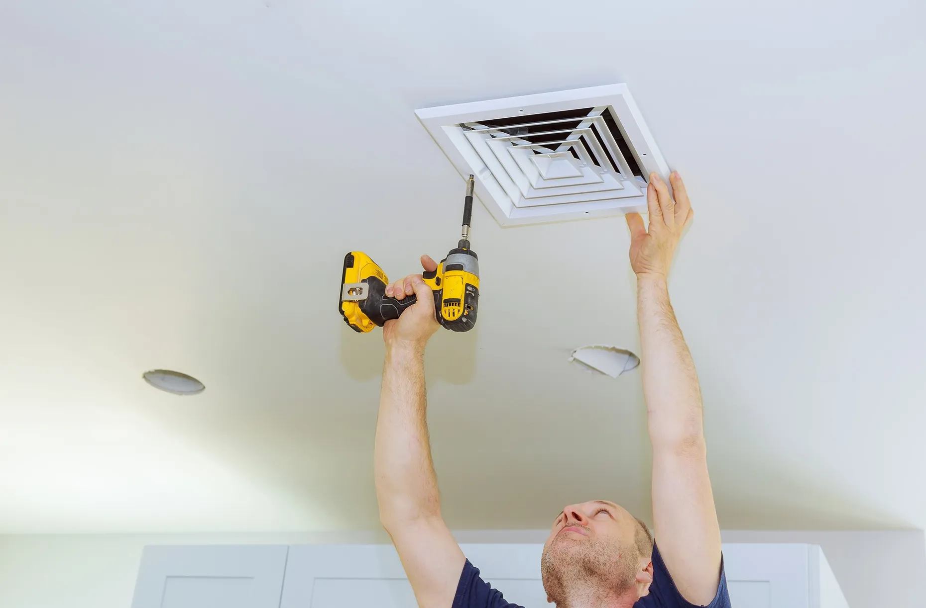 Installation d’une bouche de ventilation VMC au plafond à la visseuse